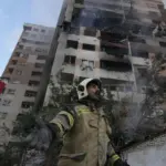 Bombero en frente de un edificio en llamas